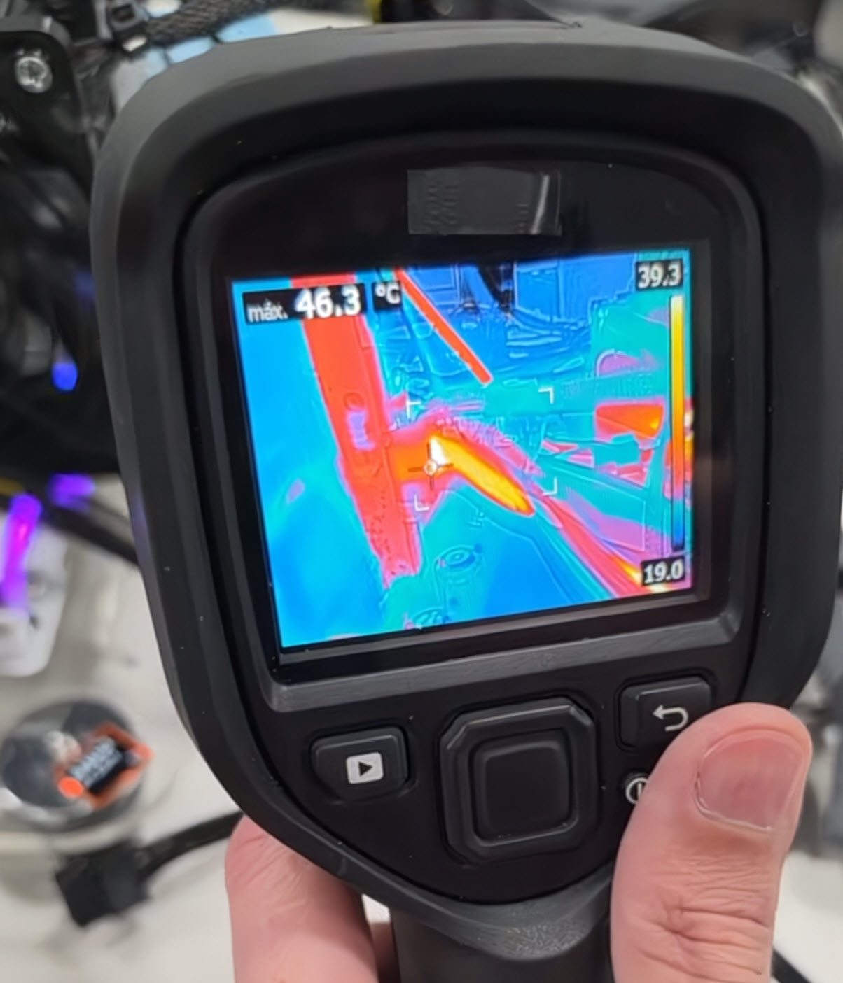 A thermal imaging camera display shows a heat map with a maximum temperature of '46.3°C'.